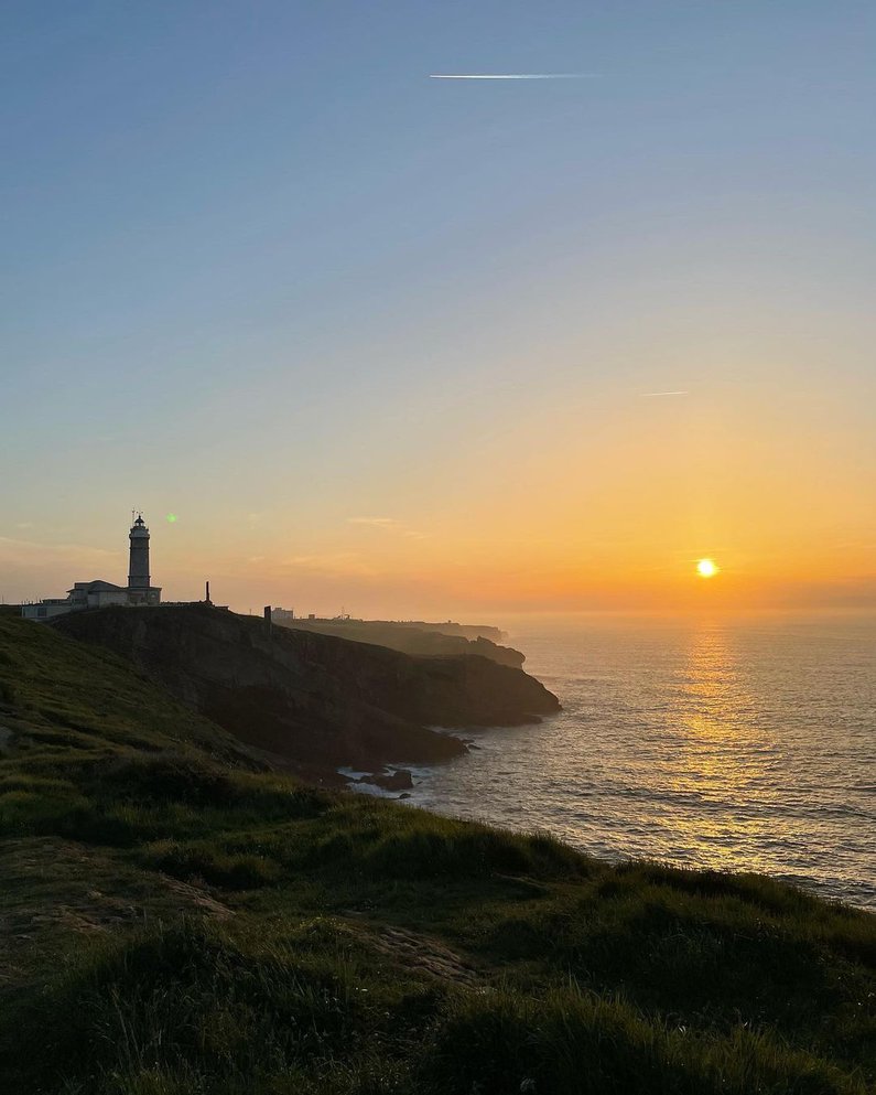 Sonnenuntergang mit einem Leuchtturm an der Küste Santanders