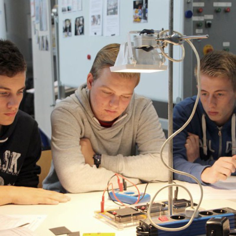 Schüler messen die Spannung an Solarpanelen mit einem Voltmeter beim Tag der Technik