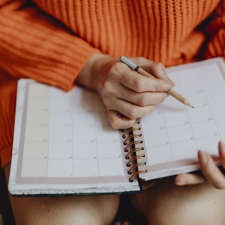 Frau trägt etwas in Taschenkalender ein