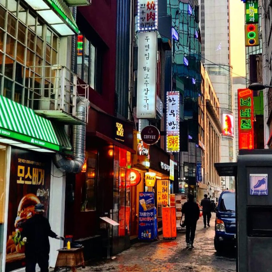 Eine Straße in Seoul mit bunten Ladenschildern.