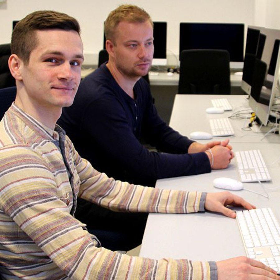 Zwei Männer sitzen im Mac-Labor der FH Kiel.