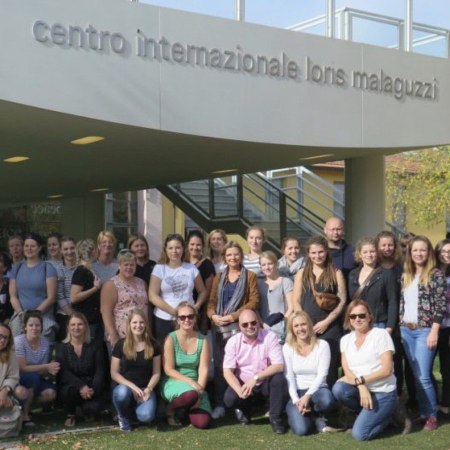 Eine große Gruppe Studierender posiert vor einem Universitätsgebäude.