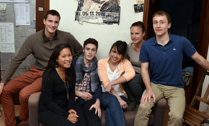 Eine Gruppe internationaler Studierender posiert zusammen in einem Cafe.
