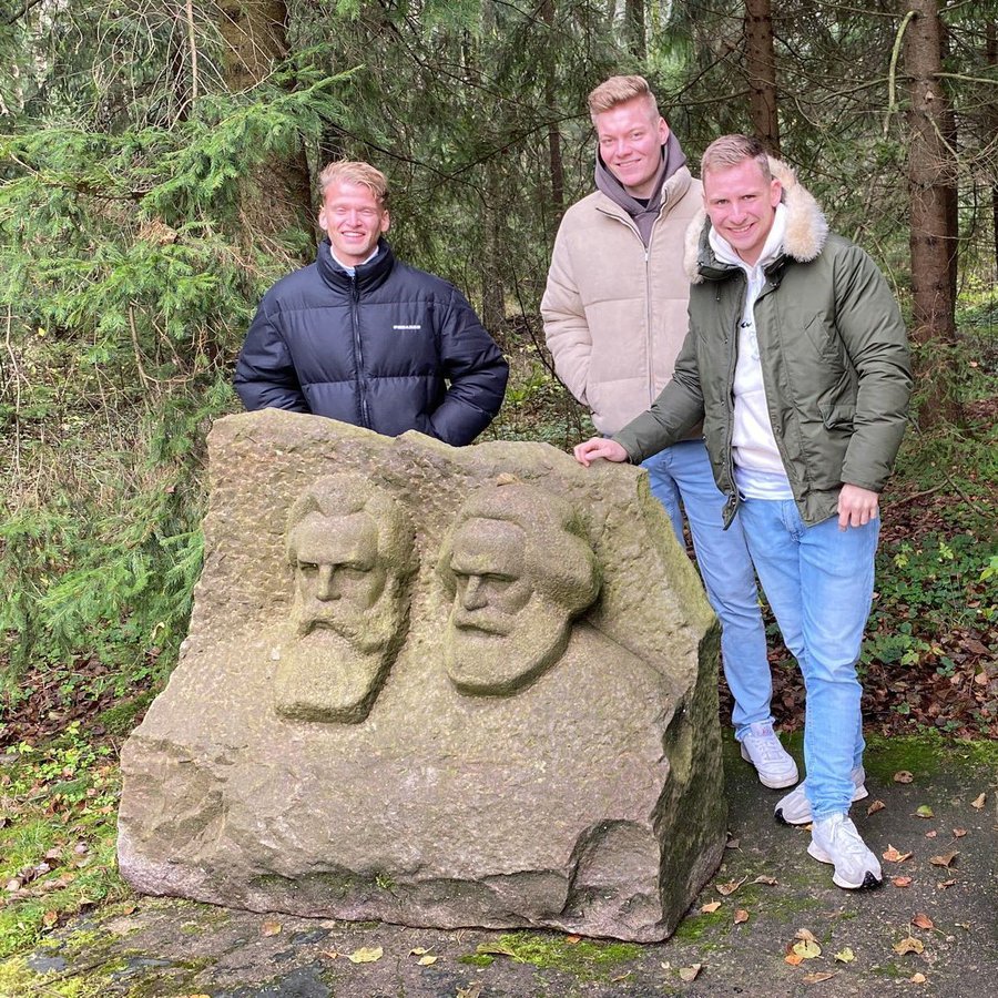 drei Personen an einem Stein