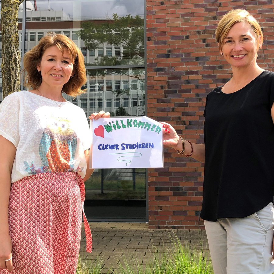 Zwei Frauen halten ein Schild