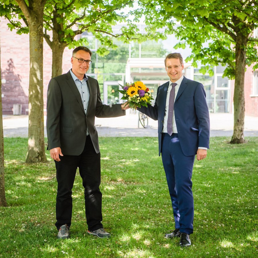 Senatsvorsitzender Prof. Dr. Claus Neumann (links) überreicht Prof. Dr. Tobias einen Blumenstrauß