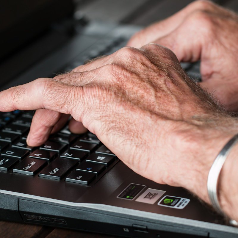 Männerhände auf Laptoptastatur
