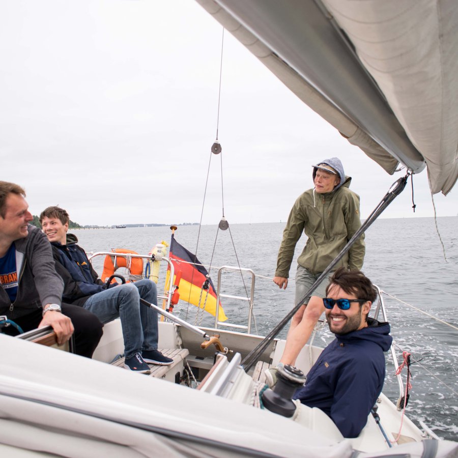 Vier Menschen auf einem Segelboot.