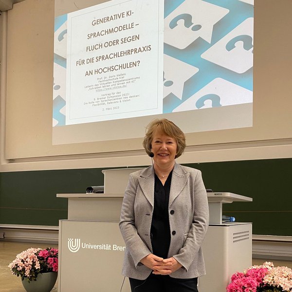 Frau Prof. Dr. Doris Weßels steht an der Uni Bremen in einem Hörsaal vor einer Projektionsfläche
