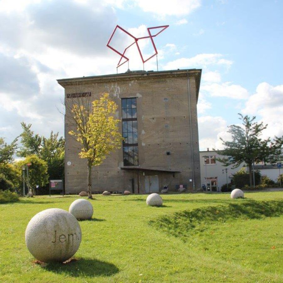 Über einen grünen Rasen hinweg wurde der Seiteneingang des Bunker-D fotografiert.