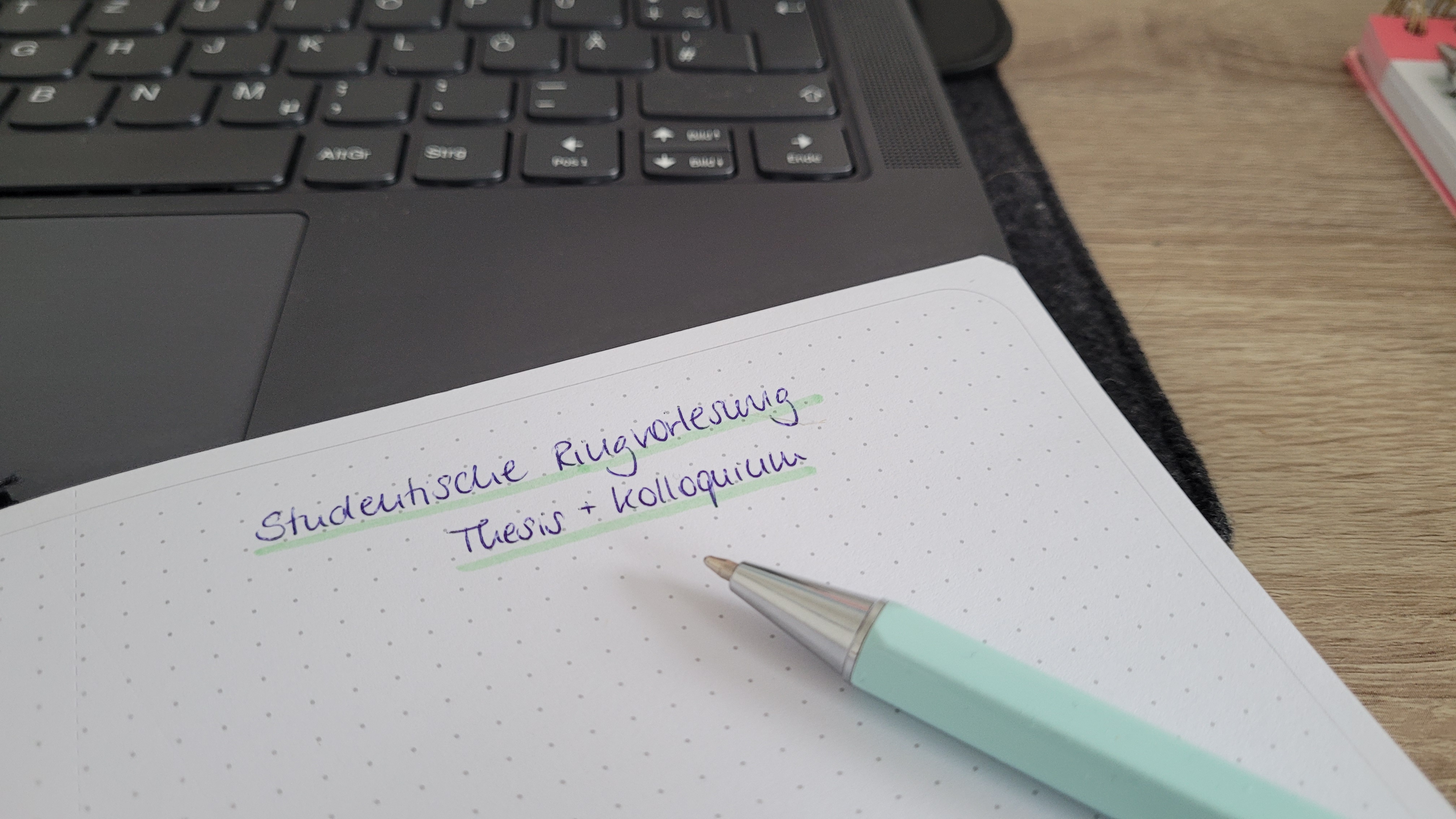 Ein Stift und ein Notizbuch auf einem Laptop