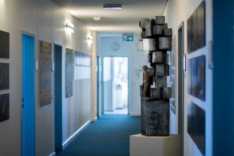Der Flur des Präsidiums mit einer Skulptur, in der eine Figur mehrere Klötze bestaunt.