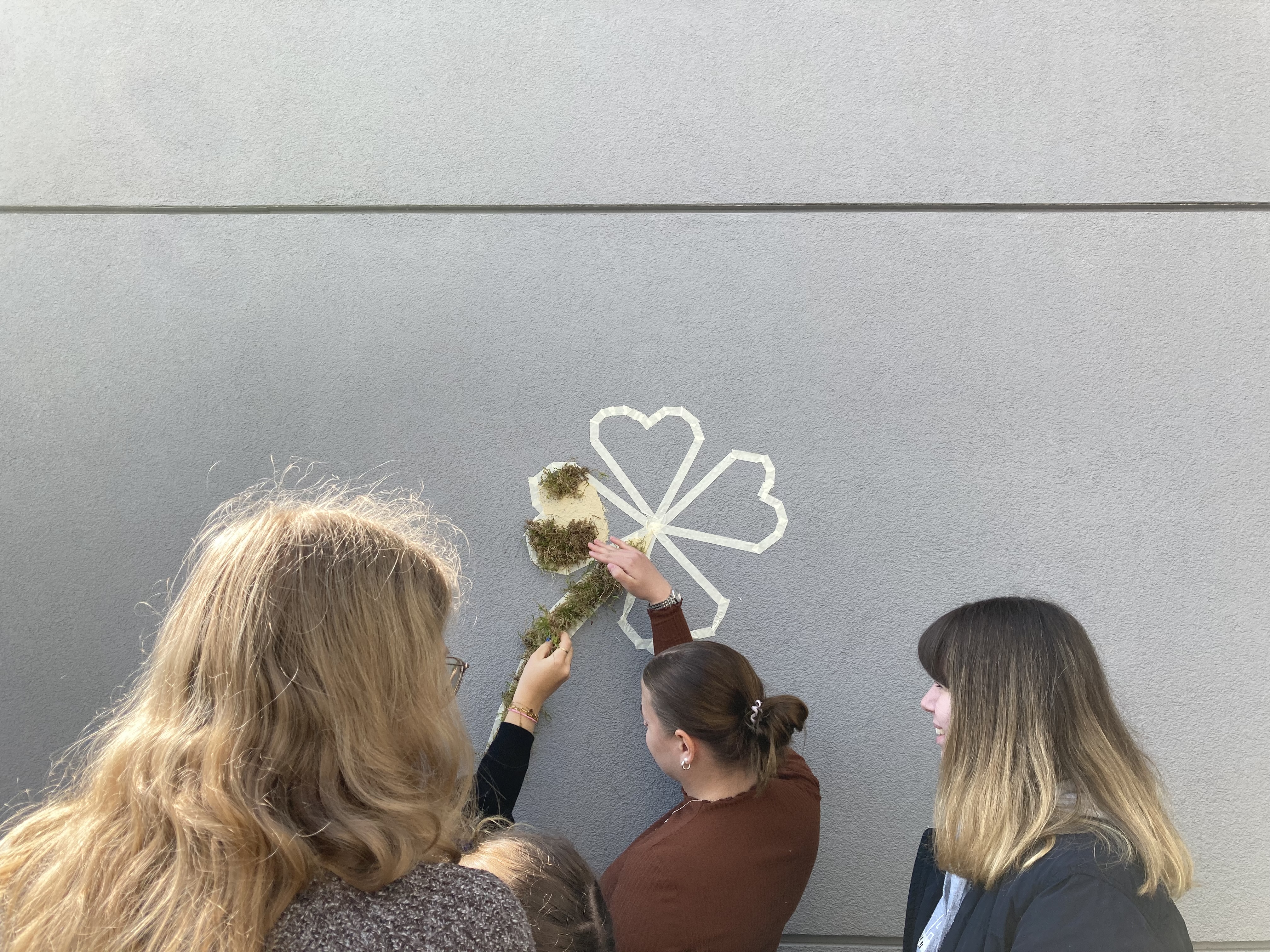 Schülerinnen und Studierende gestalten gemeinsam ein Moosgraffiti