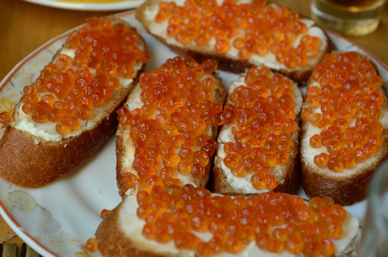 Mit Butter und orangenem Kaviar belegte Häppchen.