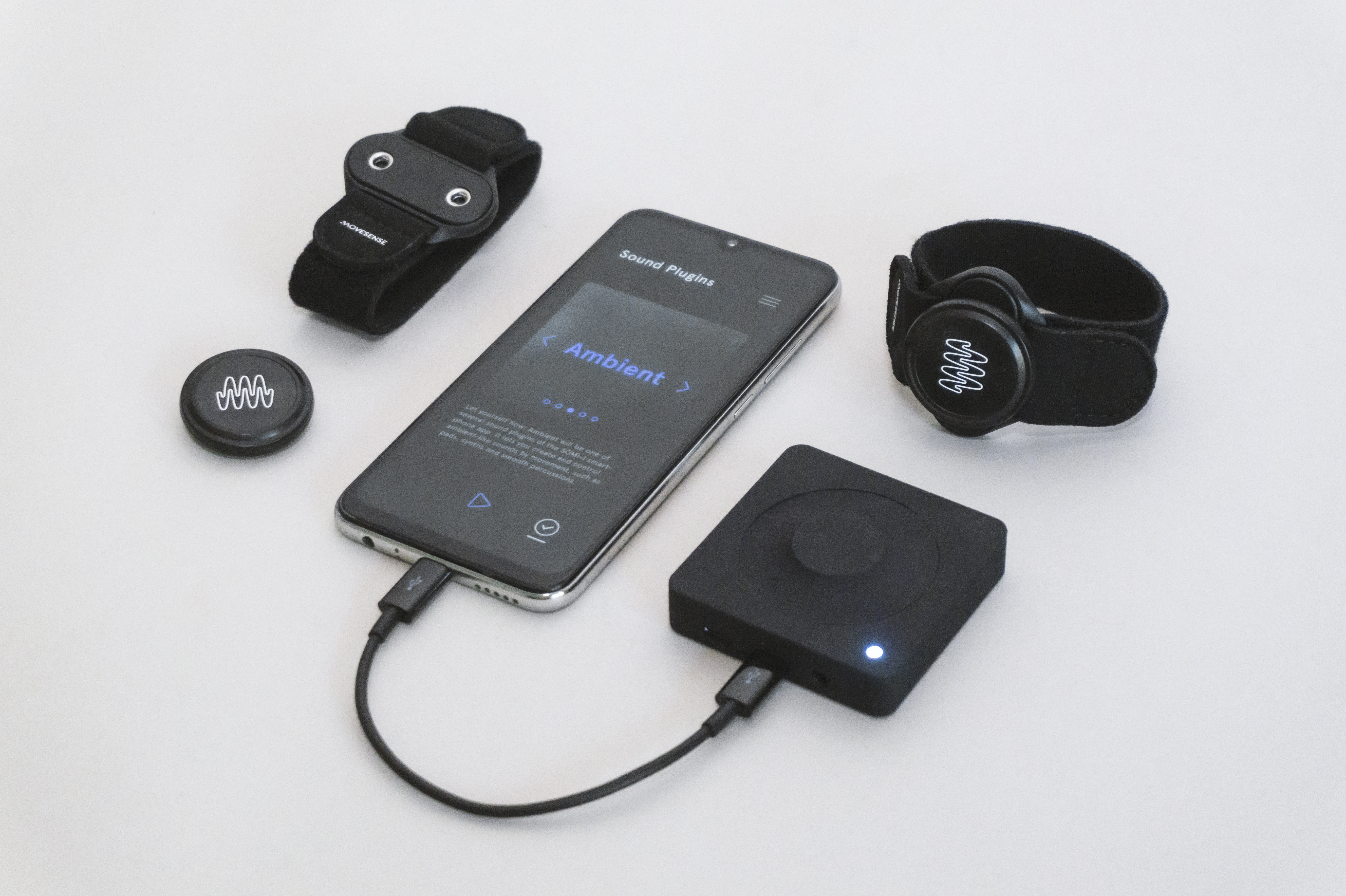 Das SOMI-1-Kit, bestehend aus Bluetooth-Sensoren, Armbändern, Kleidungsclip, Empfänger und Smartphone-App.