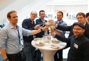 Ein Gruppe Männer stößt zufrieden mit einem Bier an.