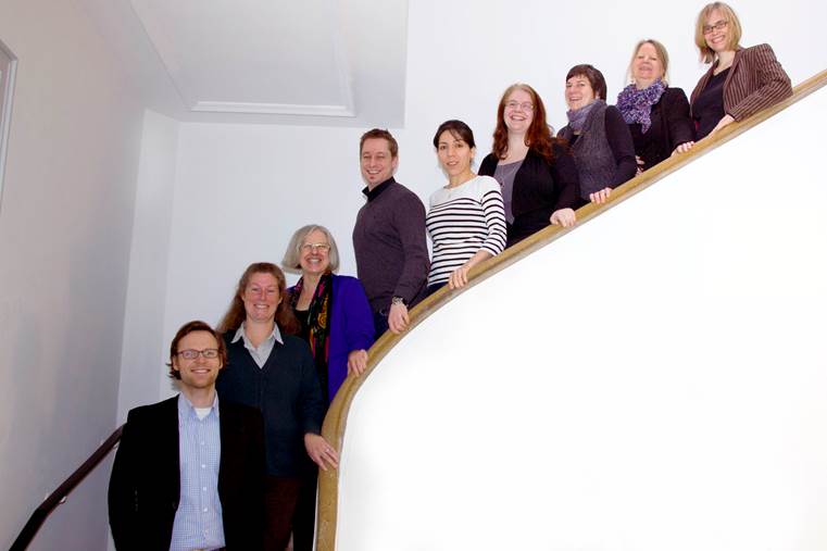 Das zu einem Großteil aus Frauen bestehende Team von MeQs, posiert auf einer Treppe.