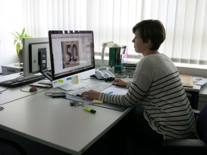 Eine Frau sitzt in ihrem Büro, vor ihrem Computer.