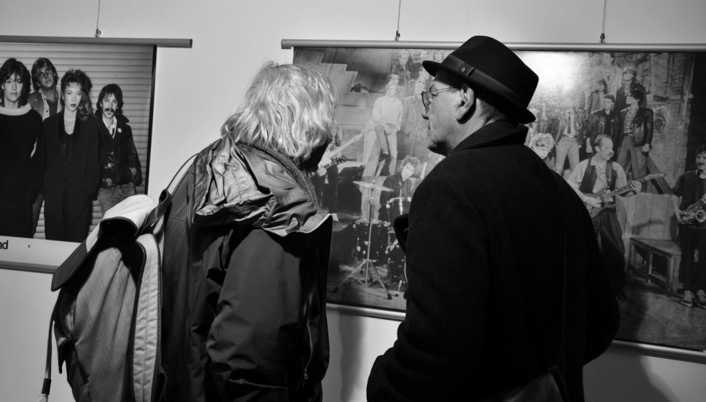 Das Schwarz-Weiss-Foto zeigt zwei Männer, die sich ein Werk von nahem anschauen.