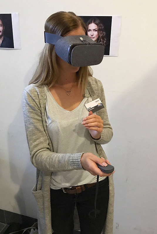 Eine Frau mit VR-Brille und Fernbedienung.