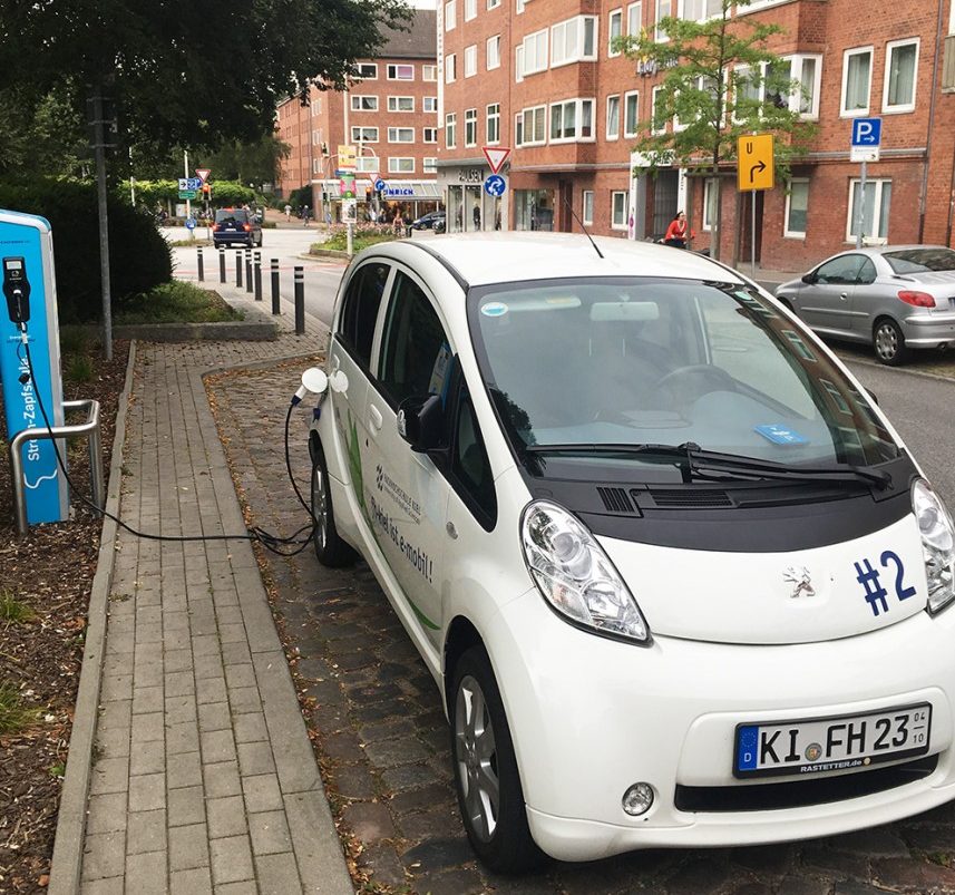 Ein parkendes eAuto steckt an der Ladestation.