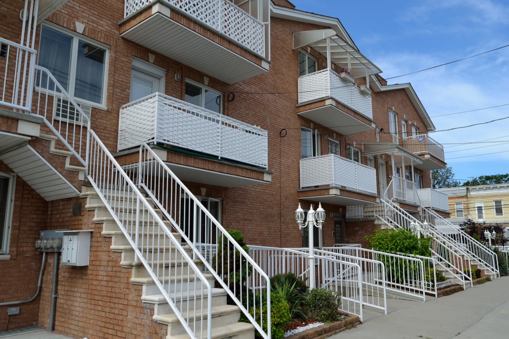 Verbundene Wohneinheiten mit ihren Treppenaufgängen und weissen Balkonbrüstungen.