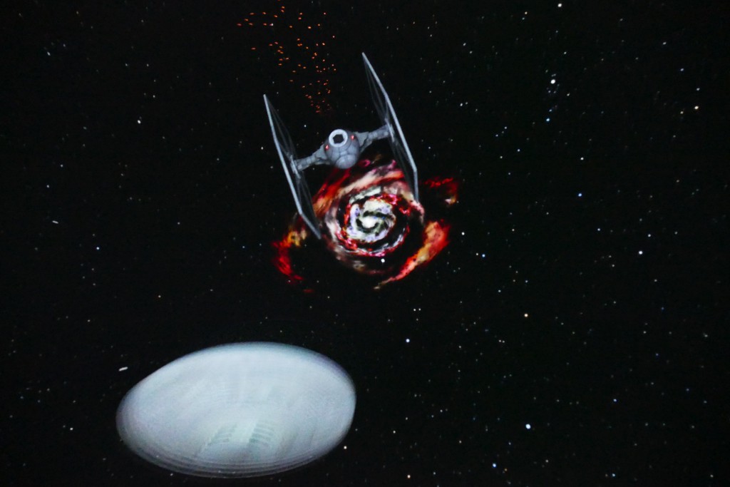 Ein Raumschiff in den Weiten des Weltalls. Im Hintergrund ist eine rote Galaxie zu sehen.