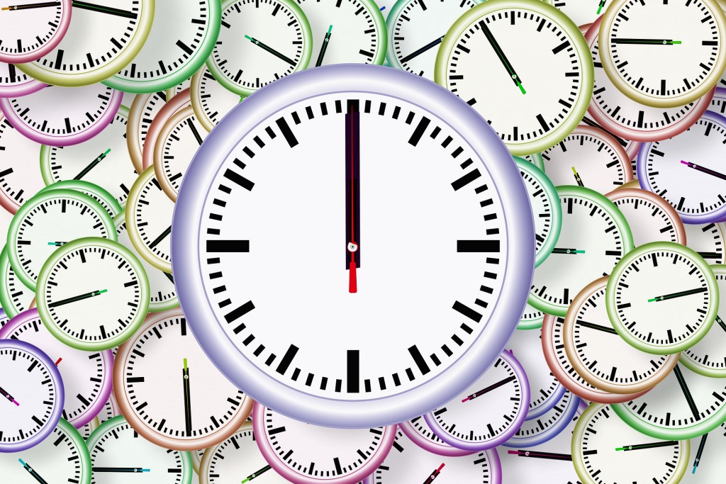 Die bunte Grafik zeigt eine Uhr, die auf ganz vielen kleineren Uhren liegt