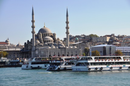 Im Hafen der Stadt liegen in türkis farbenem Wasser, mehrere Schiffe für Rundfahrten an.