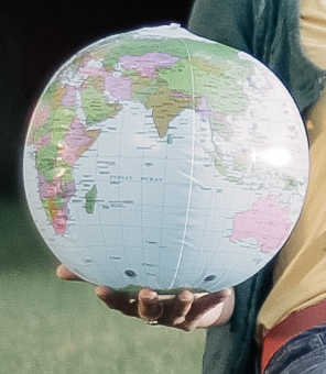 Eine Person hält einen aufblasbaen Globus auf der Handfläche.